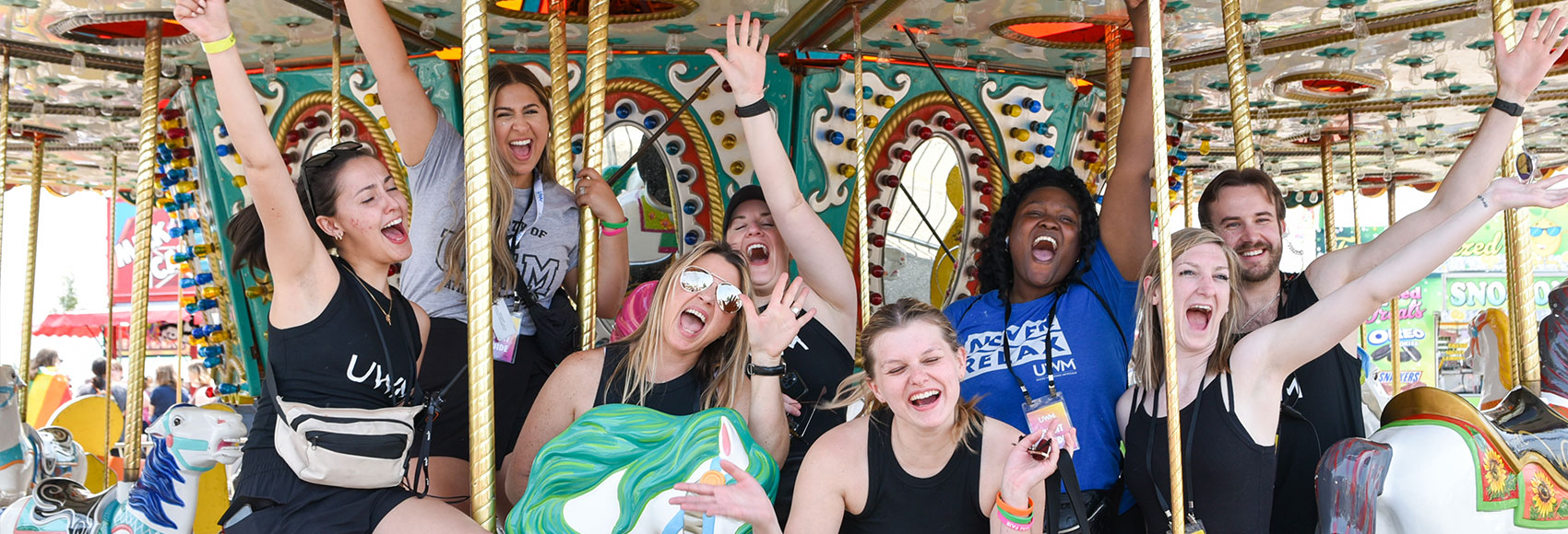 Landing page banner showing several UWM team member having fun at the yearly UWM Fair