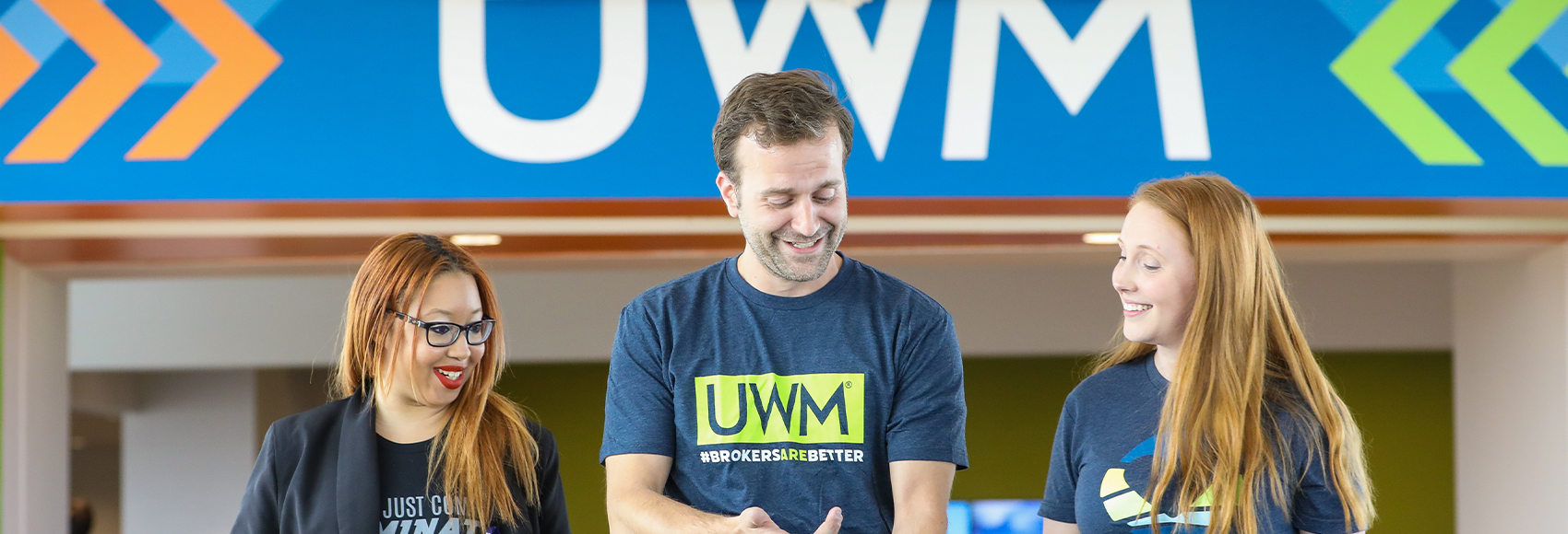 Landing page banner showing three UWM team member happy on the largest enclosed pedestrian bridge in the country