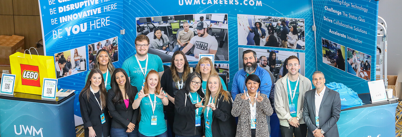 Landing page banner showing several UWM team members in front of a UWM booth at a conference