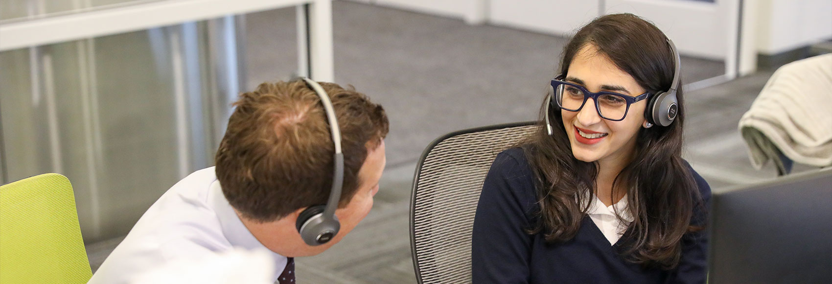 Landing page banner showing several team members happily looking over a computer screen together