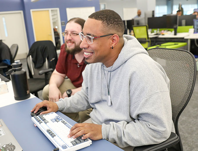 Three happy young professionals laughing in a conference room
